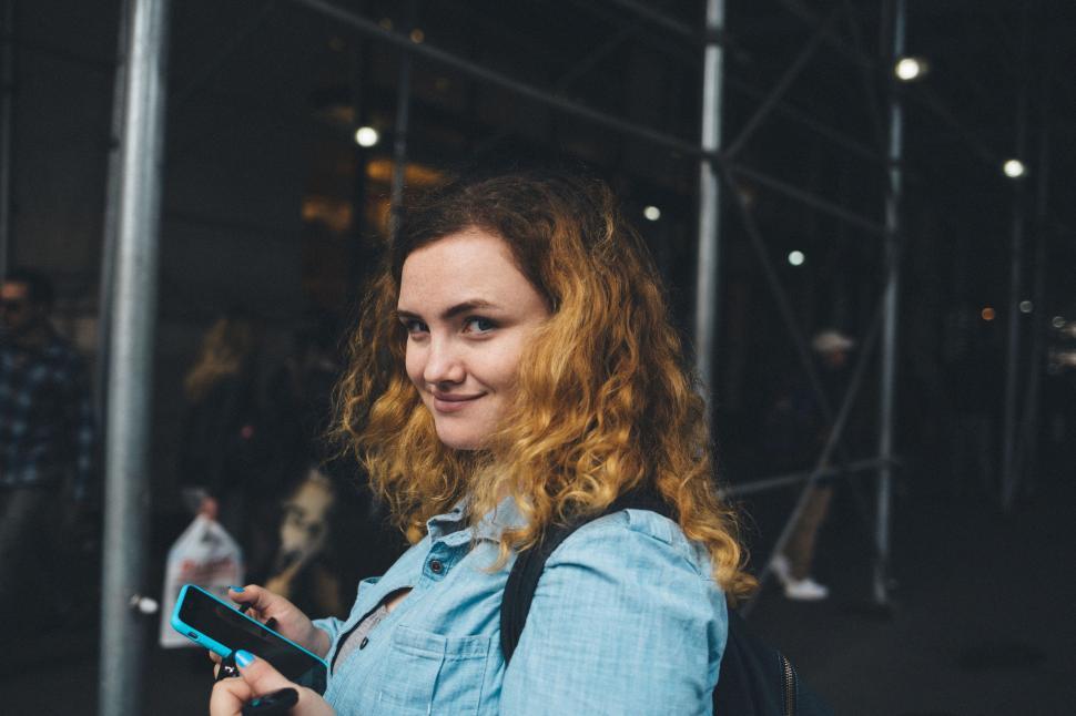 Free Image of Woman With Red Hair Holding Cell Phone 