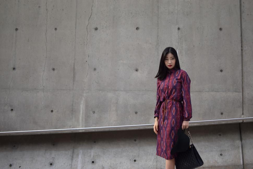 Free Image of Woman Standing in Front of Concrete Wall 