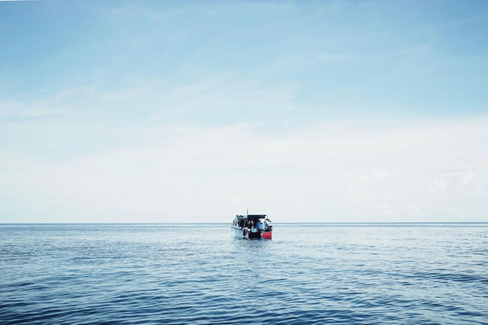 Free Image of Boat Floating on Top of Large Body of Water 