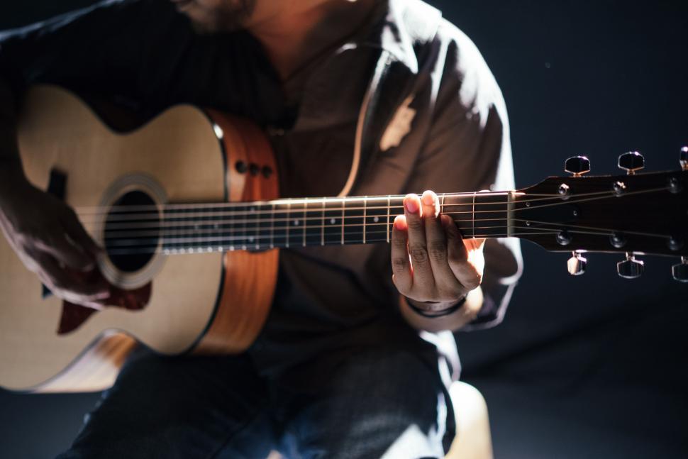 Free Image of Man Playing Guitar on Black Background 