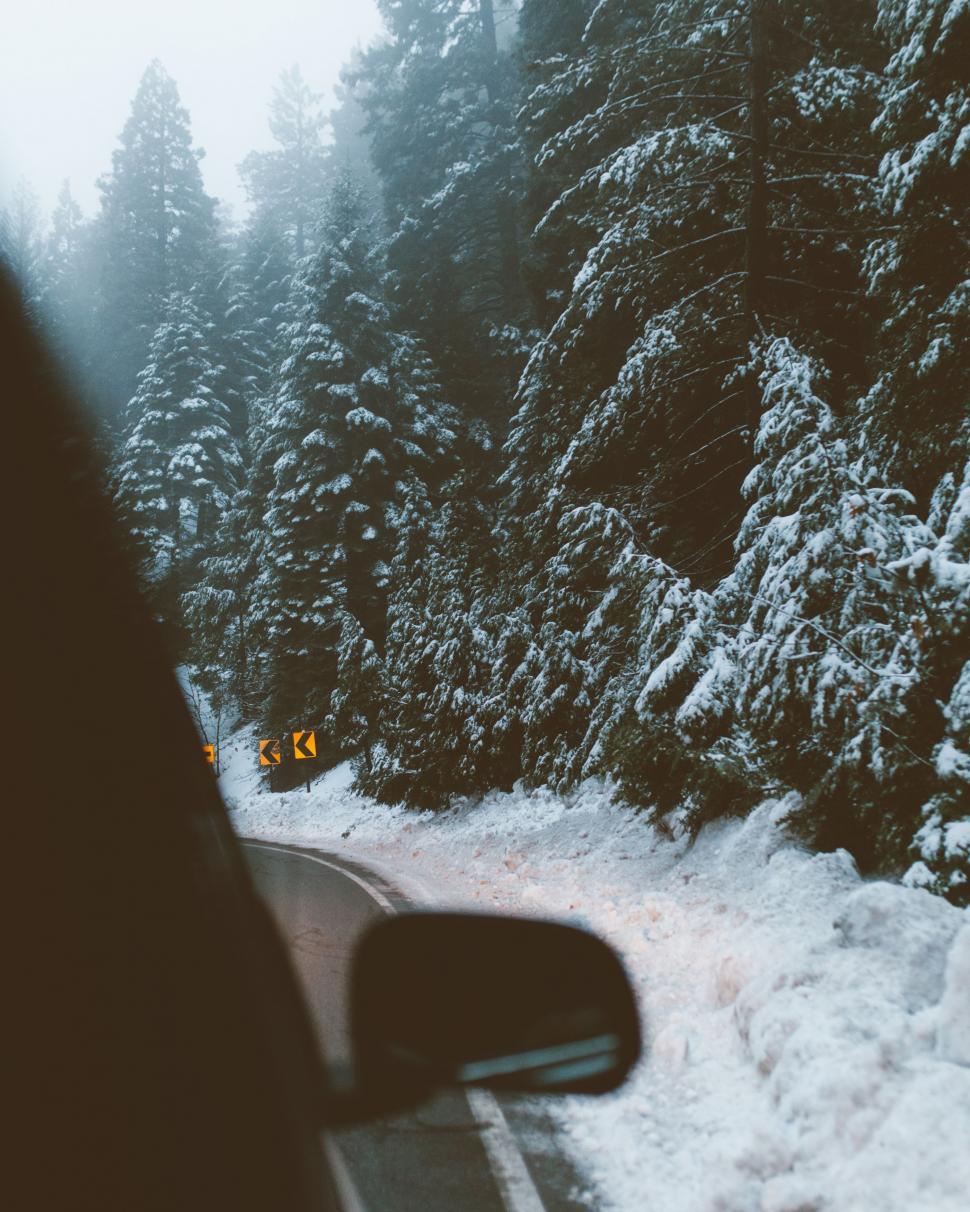 Free Image of Car Driving Down Snow Covered Road 