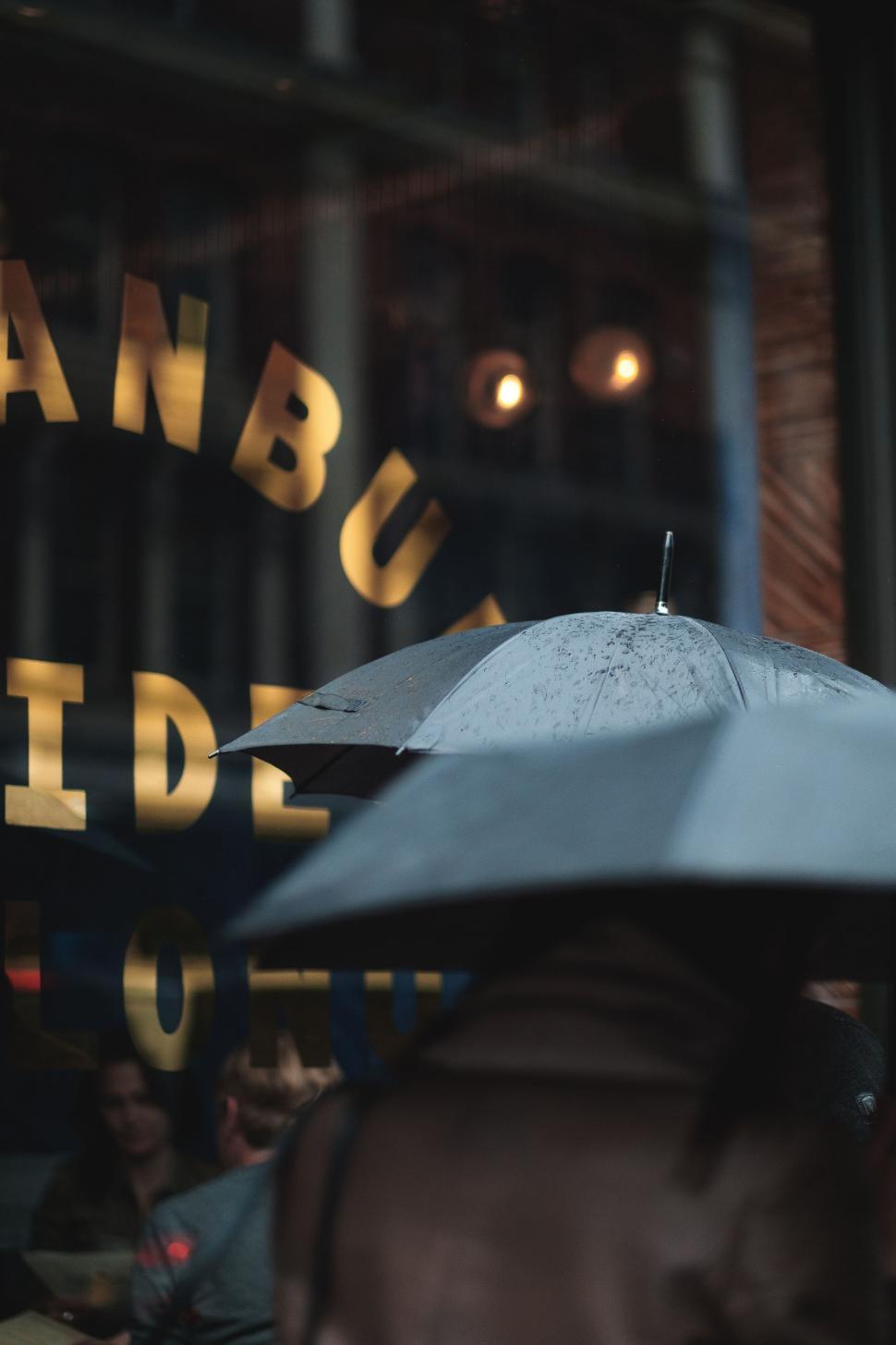 Free Image of Person Holding Umbrella in Front of Building 