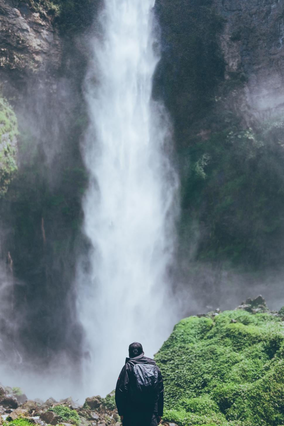 Free Image of Man Standing in Front of Waterfall 