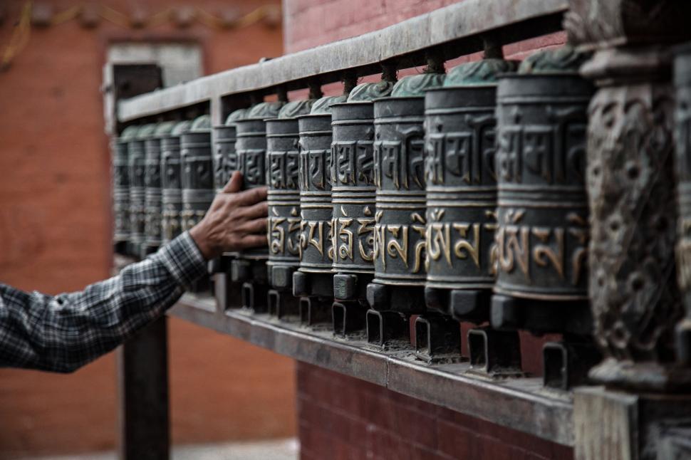 Free Image of Man Standing Next to Bunch of Bells 