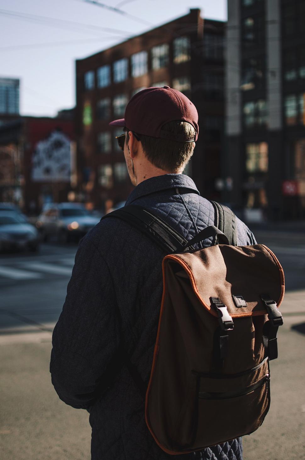 Free Image of Man Walking Down the Street With Backpack 