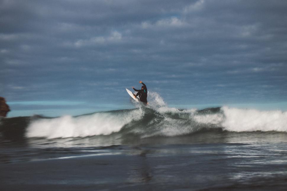 Free Image of Man Riding Wave on Surfboard 