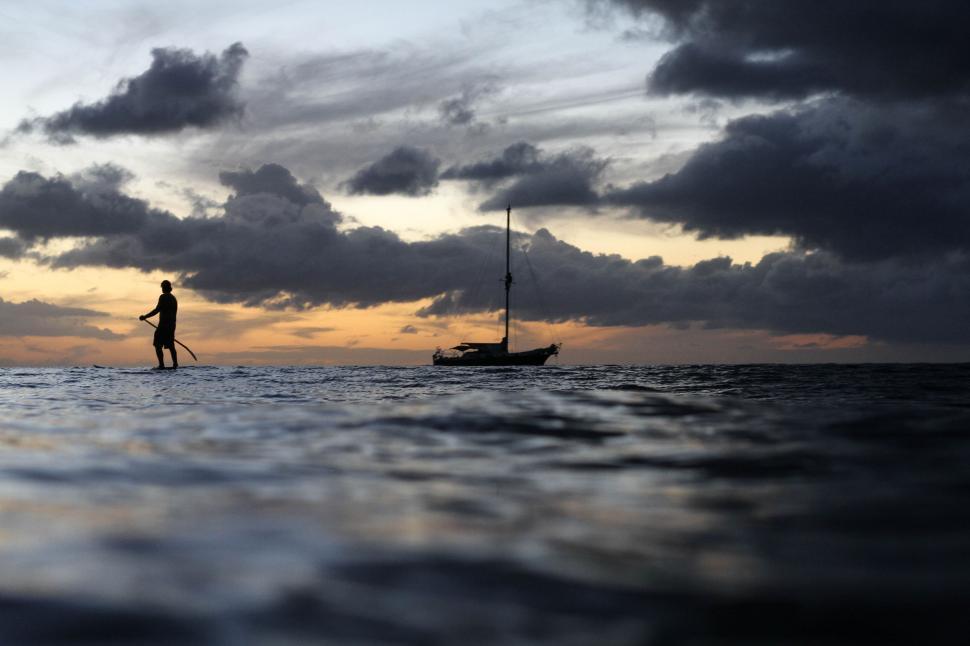 Free Image of Man Standing on Surfboard in Ocean 