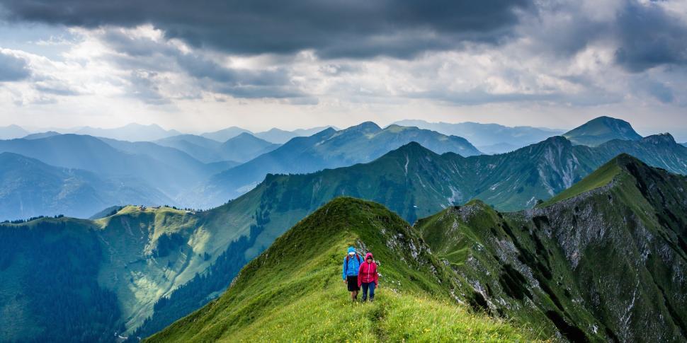 Free Image of Couple Standing on Top of Lush Green Hillside 