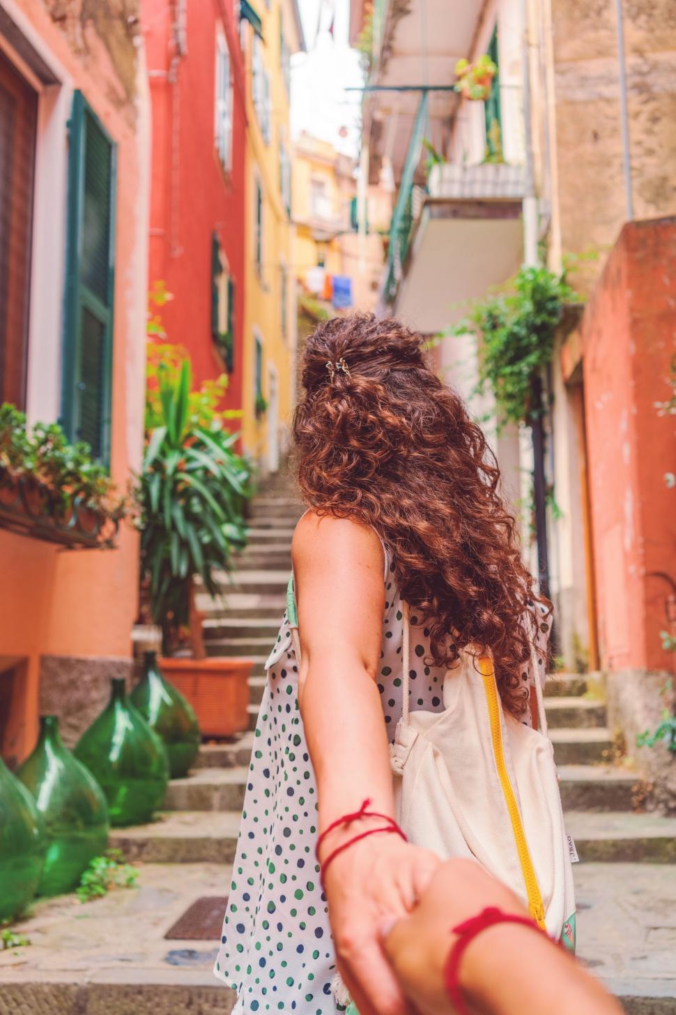 Free Image of Couple Walking Down a Street Holding Hands 