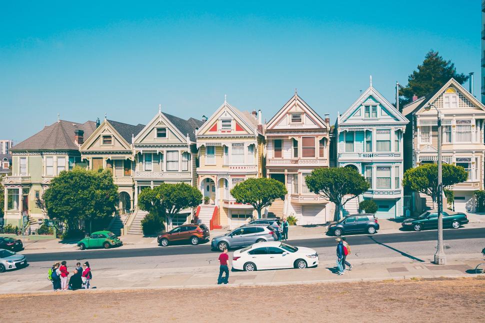 Free Image of Group of People Standing in Front of Row of Houses 
