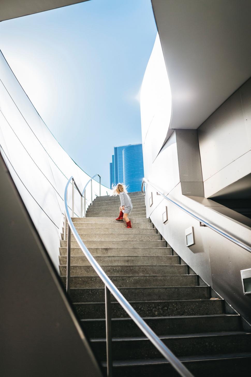 Free Image of Woman Walking Down a Flight of Stairs 