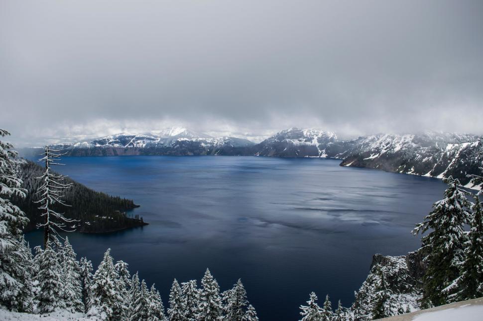 Free Image of Frozen Lake Surrounded by Snow Covered Trees 