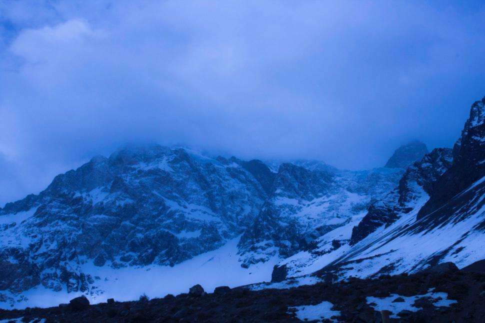 Free Image of Snow-Covered Mountain Under Cloudy Sky 