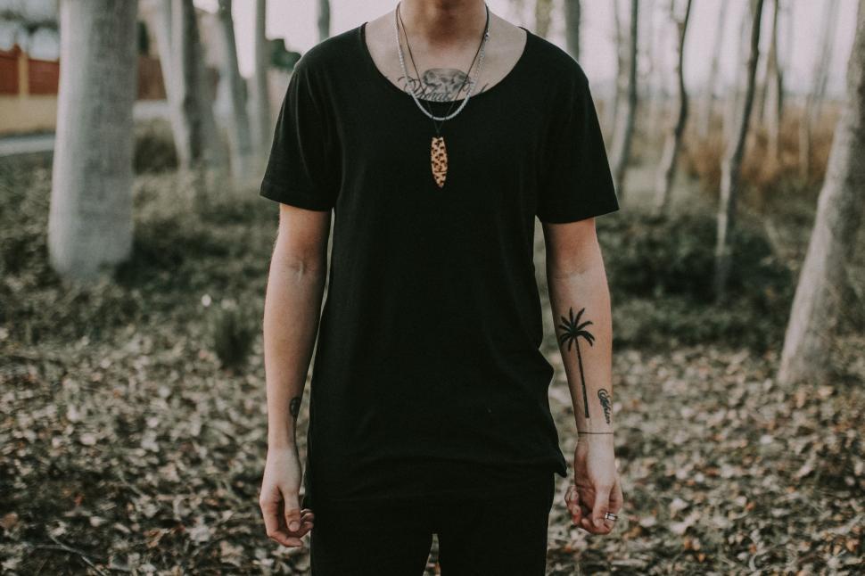 Free Image of Young Man Standing in Forest With Trees in Background 