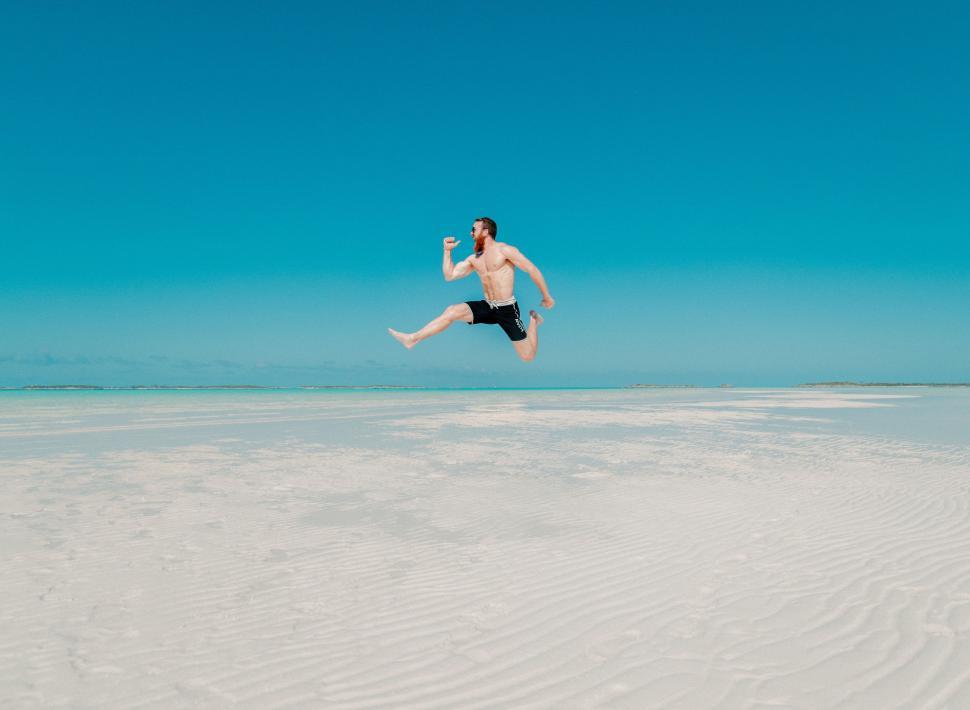 Free Image of Man Jumping in the Air on Beach 