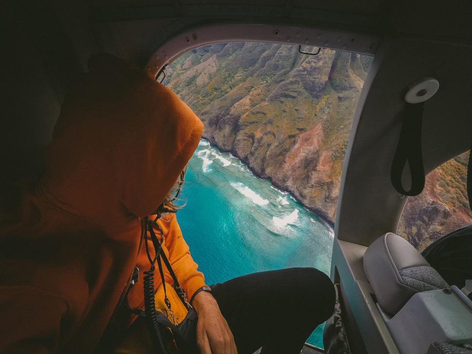 Free Image of Man in Yellow Jacket Flying Over the Ocean 