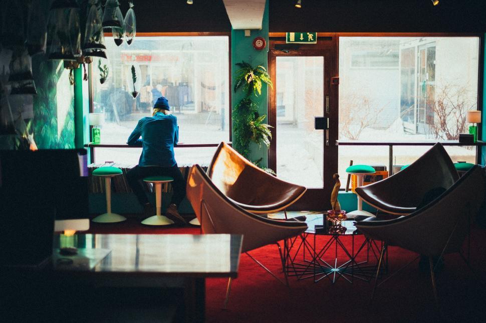 Free Image of Person Sitting at Table Looking Out Window 