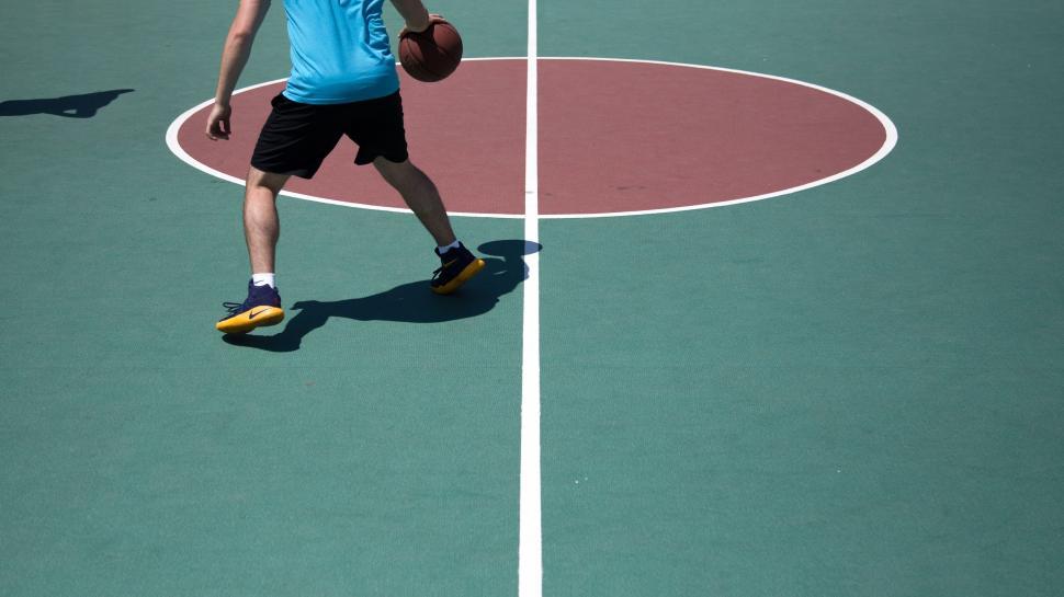 Free Image of Man Standing on Top of Tennis Court Holding a Racquet 