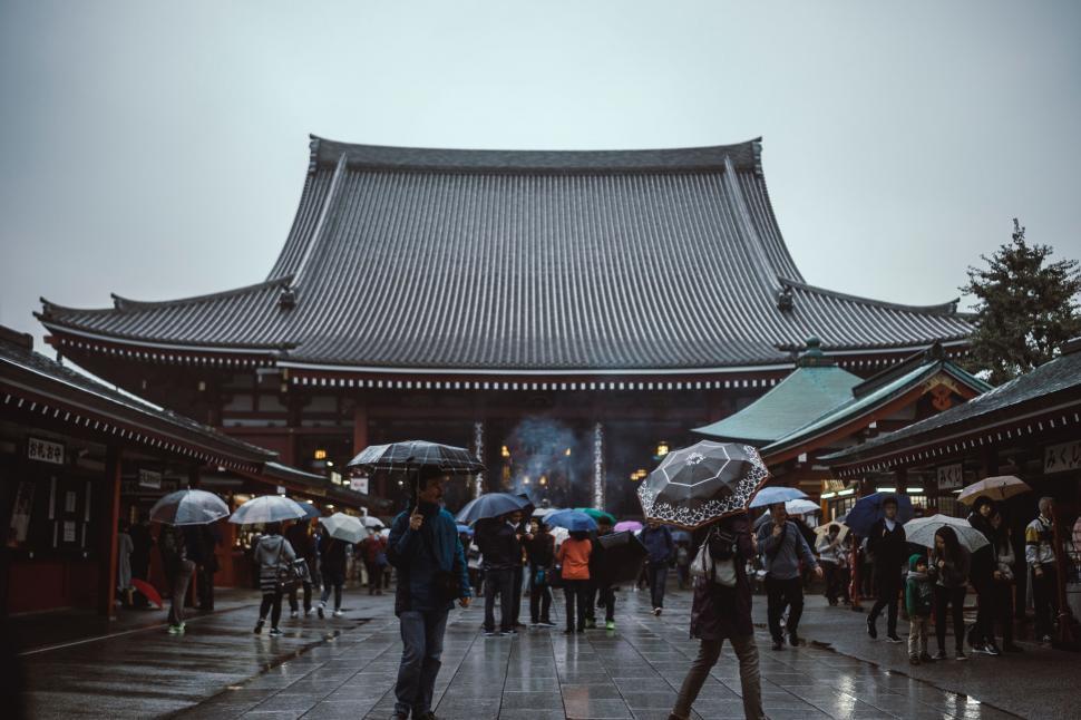 Free Image of Group of People Holding Umbrellas in Front of a Building 