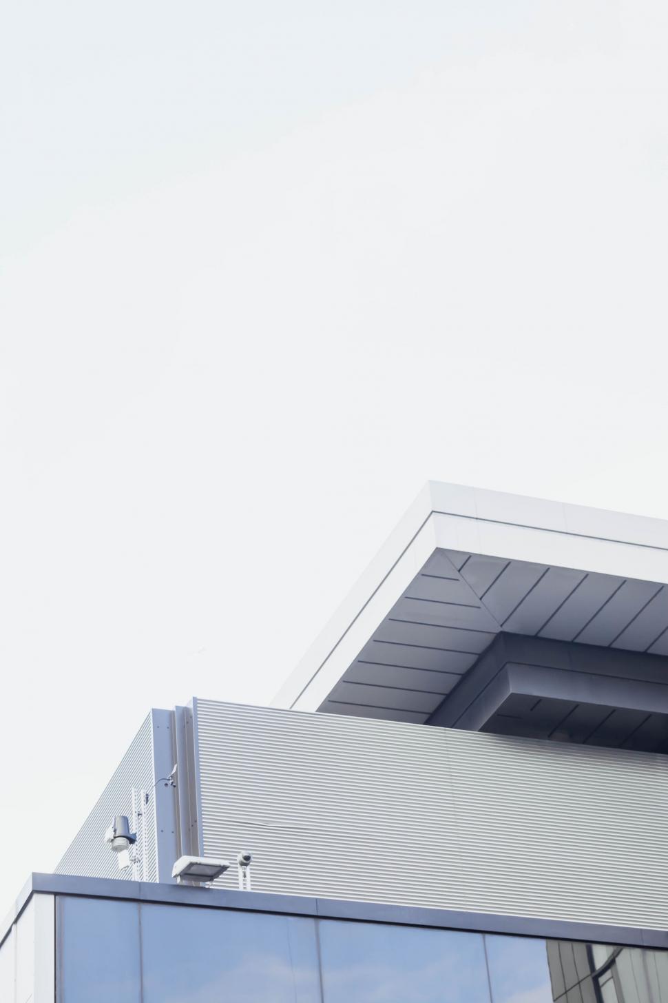 Free Image of Airplane Flying Over Building With Sky Background 