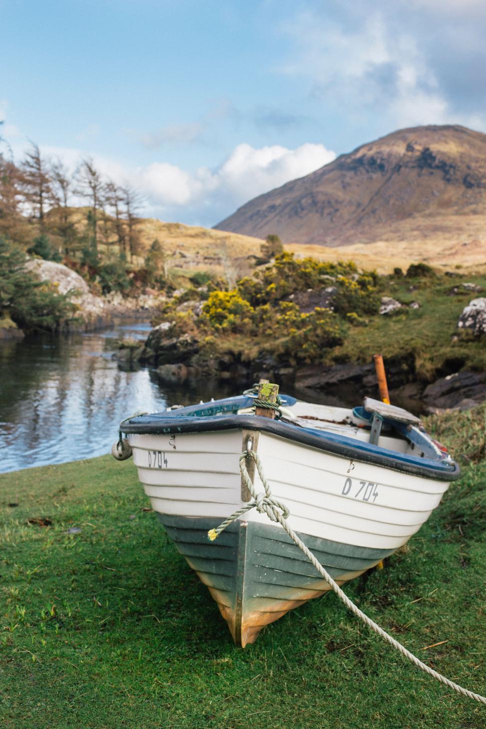 Free Image of Small Boat Resting on Lush Green Field 