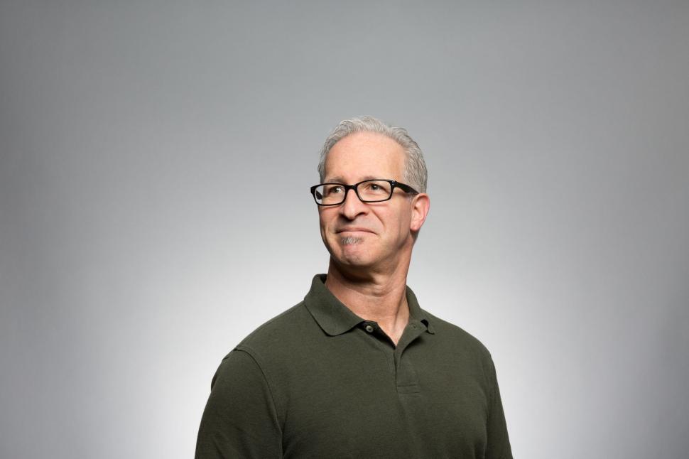 Free Image of Man With Glasses Standing in Front of Gray Background 