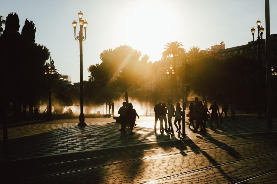 Free Image of Group of People Walking Down a Street at Sunset 