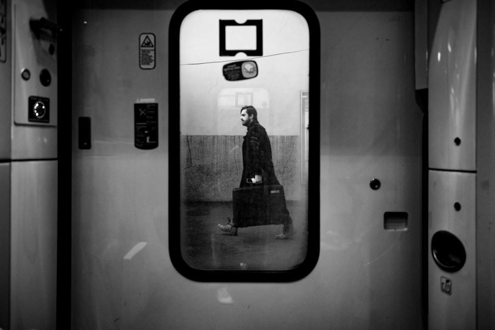 Free Image of Man With Suitcase Reflected in Mirror 
