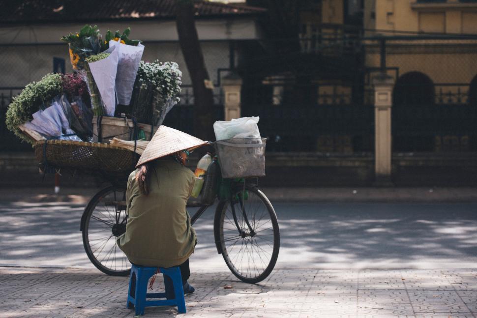 Free Image of Person Sitting on Stool Next to Bike 