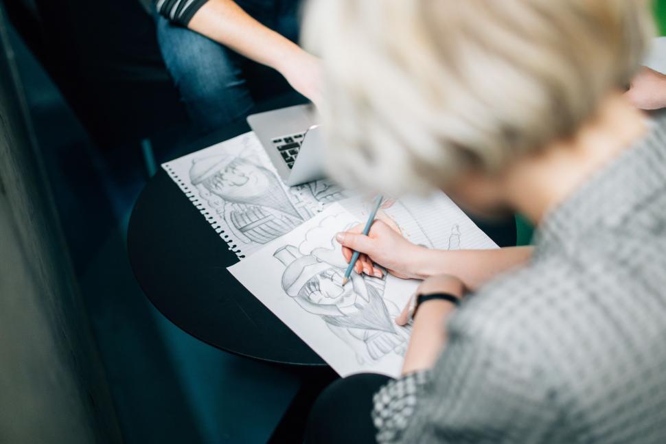 Free Image of Woman Drawing on Piece of Paper 