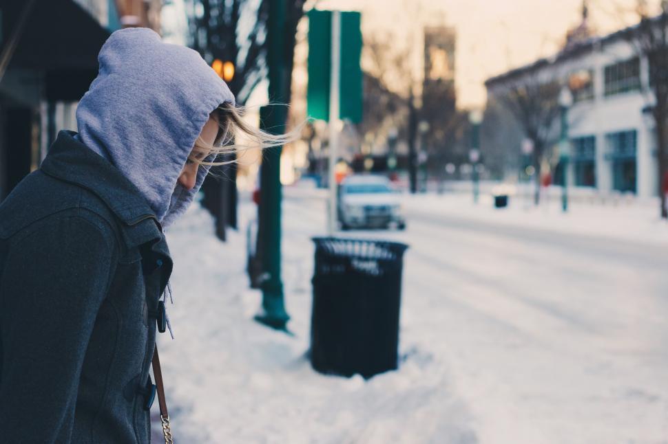 Free Image of Woman Walking Down Snow Covered Street 