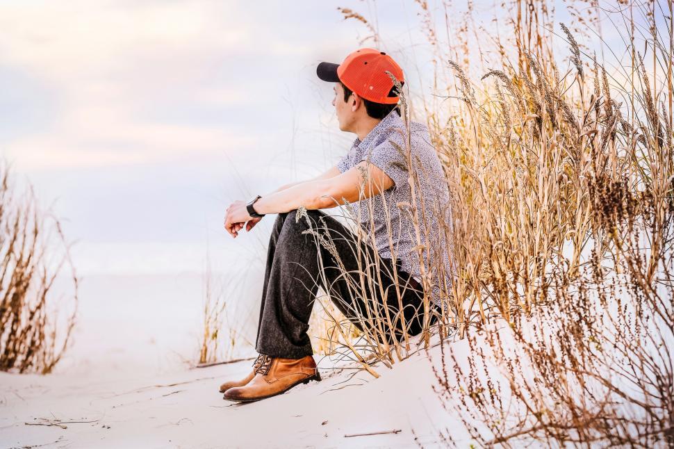 Free Image of Man Sitting on Sandy Beach 