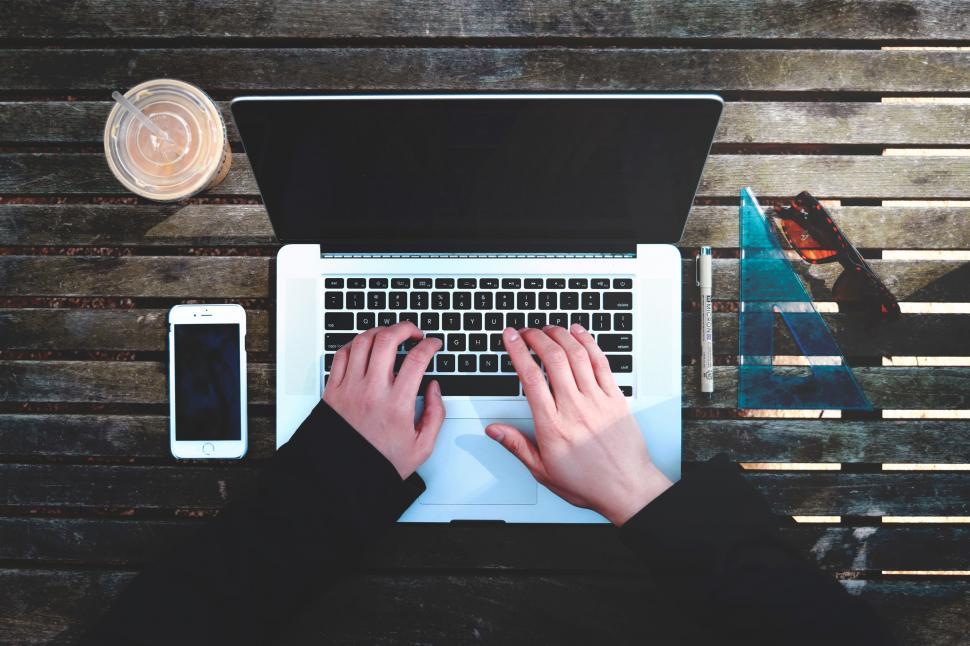 Free Image of Person Typing on Laptop on Wooden Table 