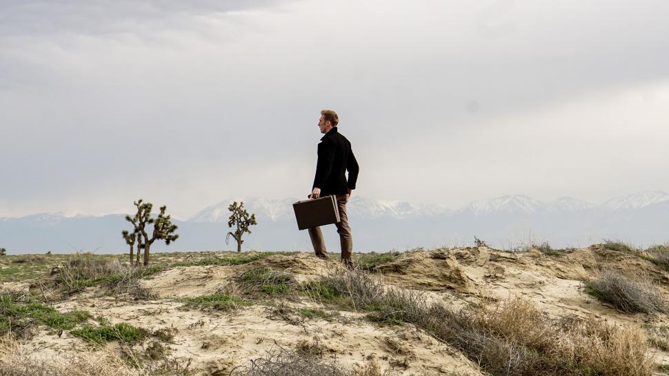 Free Image of Man Standing on Top of Sandy Hill 