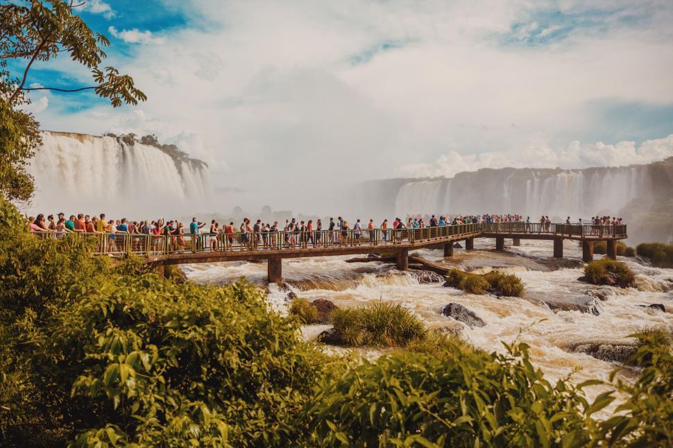 Free Image of Group of People Standing on a Bridge Over a River 