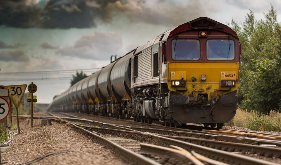 Free Image of Train Traveling Down Train Tracks Next to a Forest 