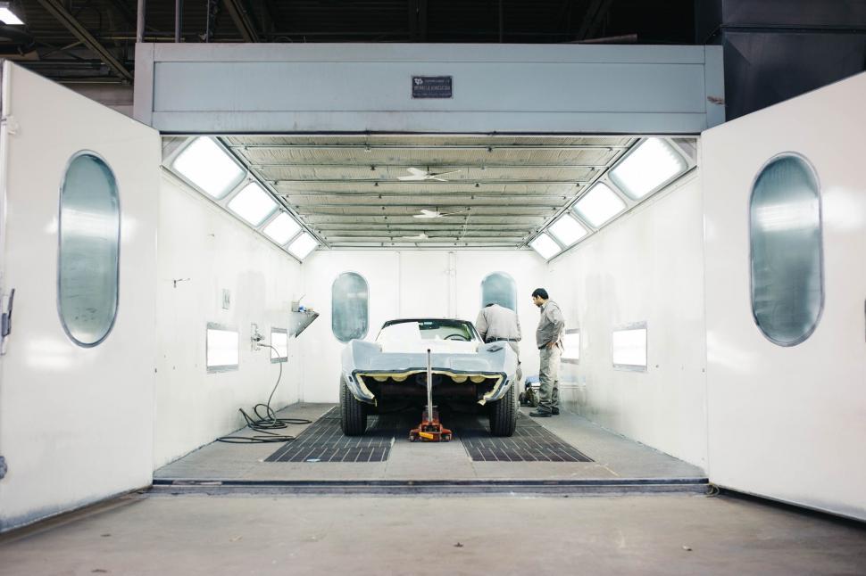 Free Image of Man Standing Next to Car in Garage 