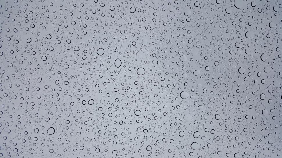 Free Image of Rain Drops on a Window With a Sky Background 