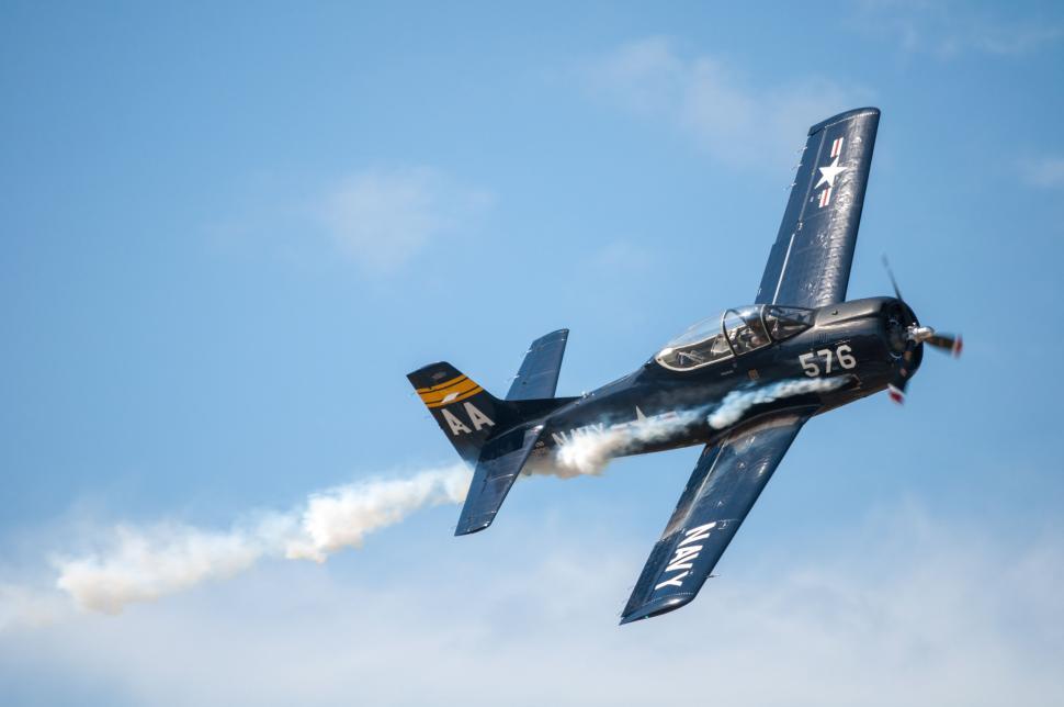 Free Image of Small Airplane Flying Through Blue Sky 