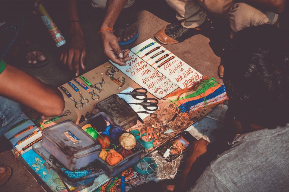 Free Image of Group of People Sitting Around Table With Assorted Items 