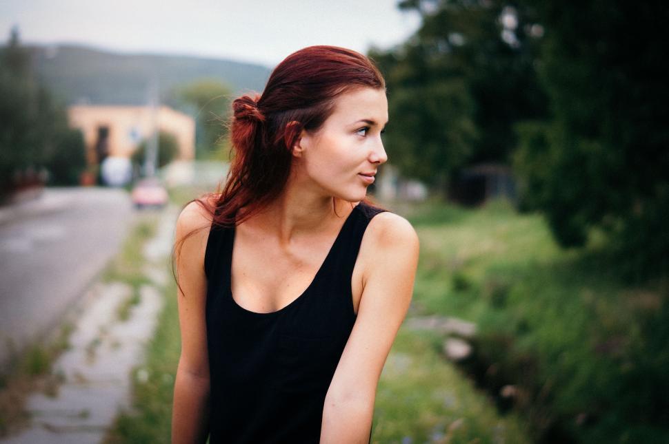Free Image of Woman in Black Dress Standing on Side of Road 
