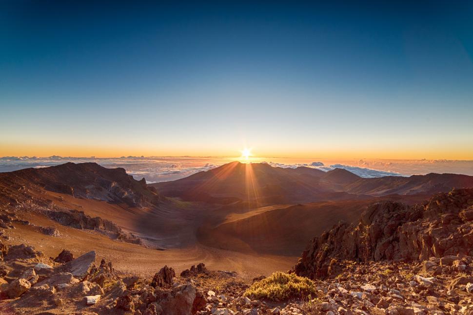 Free Image of The Sun Setting Over Mountains in the Desert 