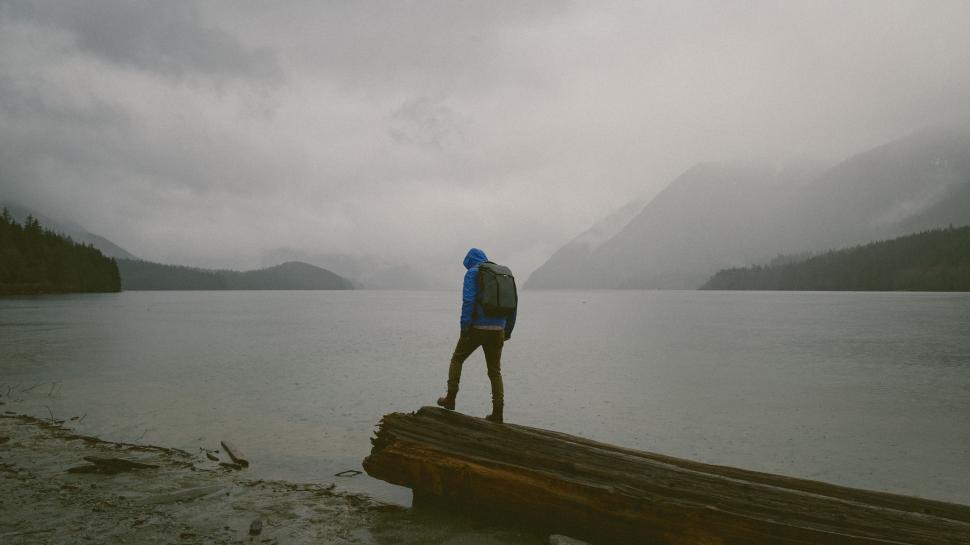 Free Image of Man Standing on Log by Water 