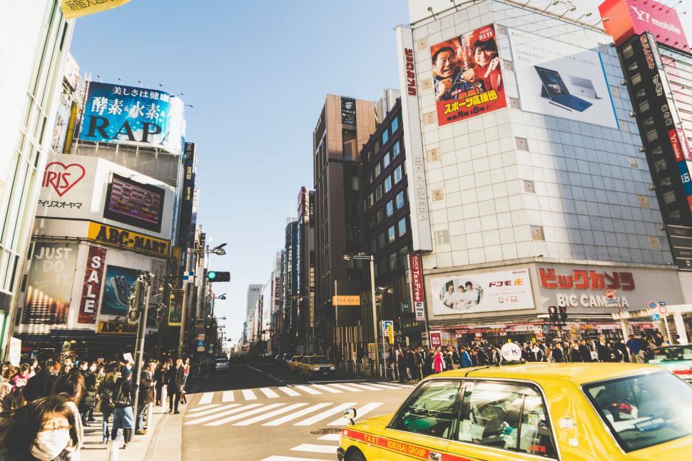 Free Image of Yellow Taxi Cab Driving Down Busy City Street 
