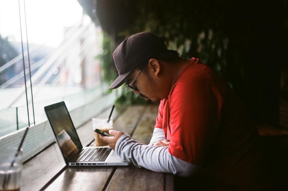 Free Image of Man Sitting at Table Using Laptop Computer 