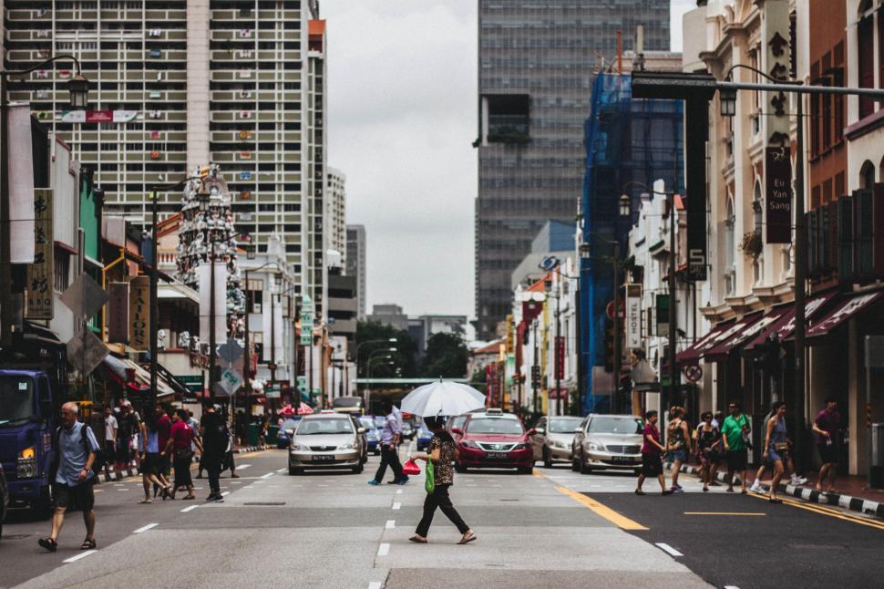 Free Image of Group of People Walking Across Street Next to Tall Buildings 