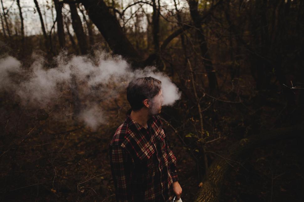 Free Image of Person Standing in Forest With Smoke Coming Out of Ears 