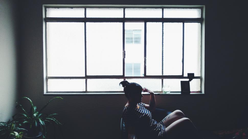 Free Image of Person Sitting on Couch by Window 