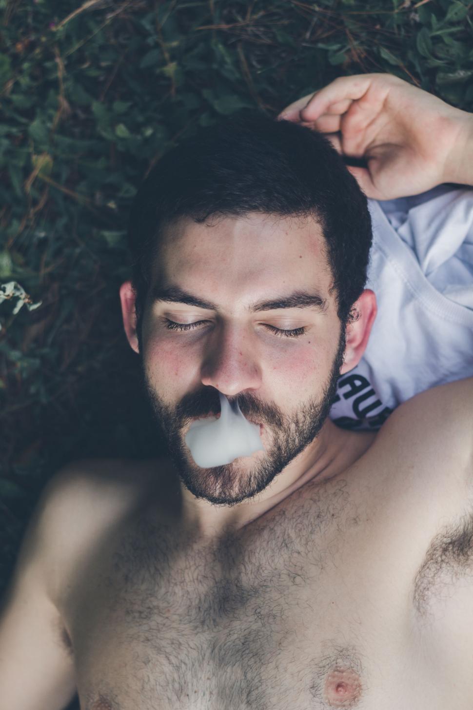 Free Image of Man Laying on Ground With Pacifier 