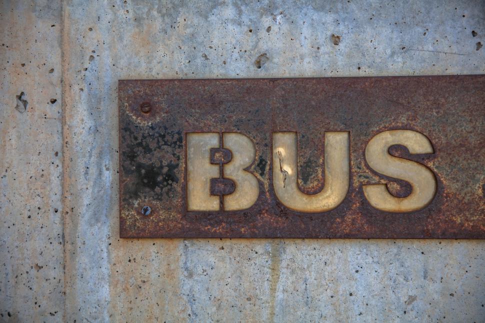 Free Image of Rusted Bus Sign on Concrete Wall 